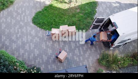 High Angle View Of Delivery Men Unloading The Cardboard Boxes From Truck Stock Photo