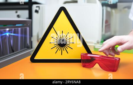 Laser safety sign next to safety glasses in a laboratory. Stock Photo