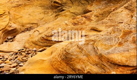 Hopeman Moray Coast Scotland wave patterns of honey or golden colour in the sandstone Stock Photo