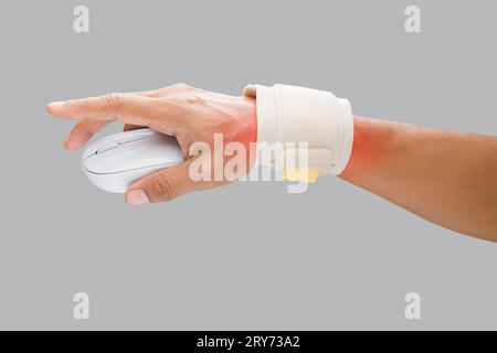 The man uses a wrist restraint to support his wrist and prevent pain while using the mouse during work. Stock Photo