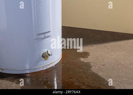 Water leaking from a residential electric water heater sitting on a