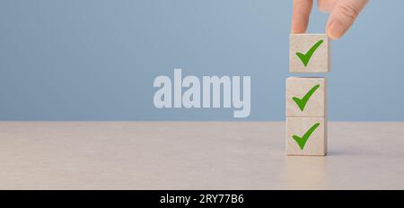 checklist and green check mark icons on wooden cubes on table background. Business task sign appointment schedule concept. Businessman placing correct Stock Photo