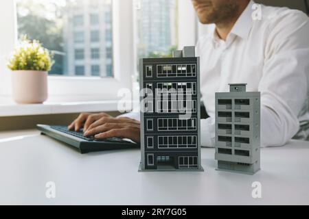 real estate business and development. businessman, developer or architect working in office, typing on computer keyboard. new apartment building scale Stock Photo