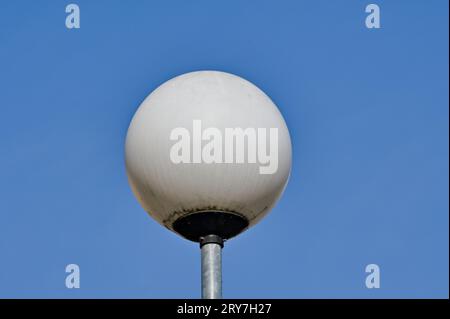 Round white streetlamp and blue sky background. Stock Photo