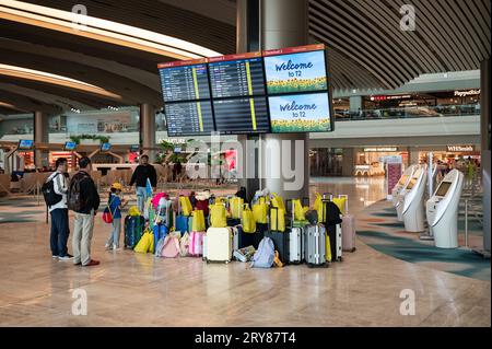 16.07.2023, Singapore, Republic of Singapore, Asia - Air travellers stand in front of flight information screens in the refurbished T2 departure hall. Stock Photo