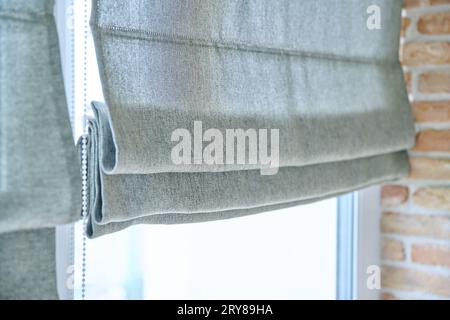 Close-up of roman blinds with gray linen fabric Stock Photo