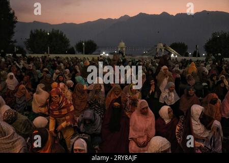 September 29, 2023, Srinagar Kashmir, India : Kashmiri Muslim women pray before the head cleric (unseen) displays the holy relic on the occasion of Mawlid-un-Nabi or Prophet Muhammad's (PBUH) birth anniversary in Dargah Hazratbal shrine in Srinagar. Hundreds of thousands of Muslims from all over Kashmir visit the Hazratbal shrine in Srinagar to pay obeisance on the birth anniversary of Prophet Mohammed (PBUH) . The shrine is highly revered by Kashmiri Muslims as it is believed to house a holy relic of the Prophet Mohammed (PBUH). The relic is displayed to the devotees on important Islamic days Stock Photo