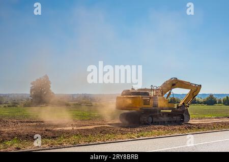 Industrial heavy duty excavator loading soil material from highway construction site. Heavy excavator working on construction site. Copyspace, nobody Stock Photo