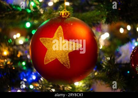 Closeup of a red  bauble with a star hanging on a Christmas tree Stock Photo