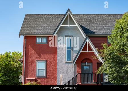 Beautiful house with shingle roof and blue sky. Edge of roof shingles on top of the house dark asphalt tiles on the roof Stock Photo