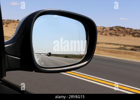 Looking backwards in car side wing mirror, right hand drive, drivers point of view Stock Photo