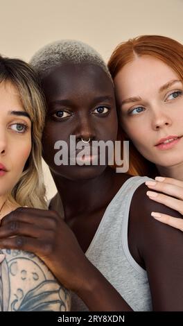 Three cool pretty young women looking at camera, beauty vertical shot. Stock Photo