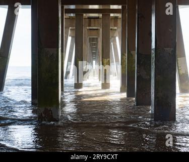 Metal beams and posts on the underside of a fishing bridge jutting out into the Atlantic Ocean. Photographed on the Outer Banks of North Carolina. Stock Photo