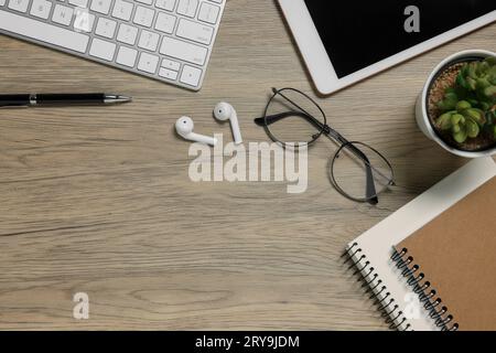 Flat lay composition with computer keyboard and different stationery on wooden desk, space for text. Home office Stock Photo