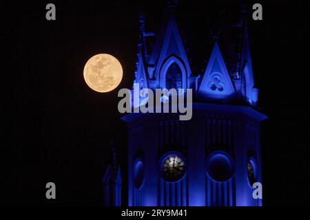 Franca, Brazil. 29th Sep, 2023. Full moon is seen next to the tower of the Cathedral of Our Lady of the Immaculate Conception in Franca, Sao Paulo, Brazil, on September 29, 2023. (Photo by Igor do Vale/Sipa USA) Credit: Sipa USA/Alamy Live News Stock Photo