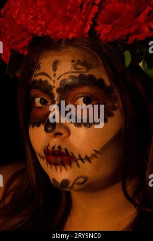 woman staring straight ahead wearing Catrina makeup representing the day of the dead in Mexico Stock Photo