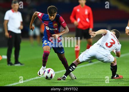 Barcelona, Spain. 29th Sep, 2023. Lamine Yamal (L) of FC Barcelona vies with Adria Pedrosa of Sevilla FC during a La Liga football match between FC Barcelona and Sevilla FC in Barcelona, Spain, Sept. 29, 2023. Credit: Joan Gosa/Xinhua/Alamy Live News Stock Photo