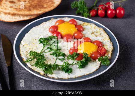 Scrambled eggs with cherry tomatoes in the shape of a flower, children's breakfast idea, closeup Stock Photo