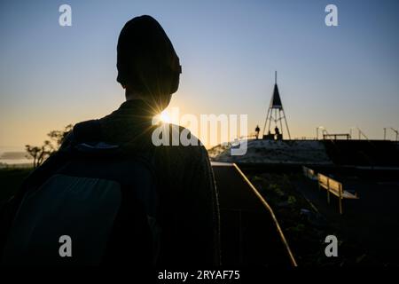 Silhouette image of man walking on boardwalk at sunrise. Mt Eden Summit. Auckland. Stock Photo