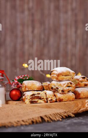 Small Stollen cake pieces, a German fruit bread with nuts, spices, and dried fruits with powdered sugar traditionally served during Christmas time Stock Photo