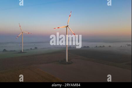 Sieversdorf, Germany. 25th Sep, 2023. Two wind turbines stand in the early morning in the Oder-Spree district. (Aerial view with a drone) Credit: Patrick Pleul/dpa/Alamy Live News Stock Photo