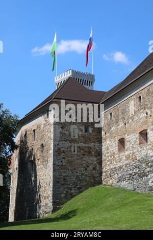Ljubljana, L, Slovenia - August 15, 2023:  Tower of ancient Castle called ljubljanski grad in Slovenian language and flags Stock Photo
