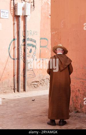 local man wearing Djellaba in the backstreets of Marrakech in Morocco March 2012 Stock Photo