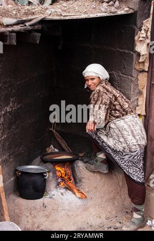 Berber local lady standing next to lit fire in Morocco March 2012 Stock Photo