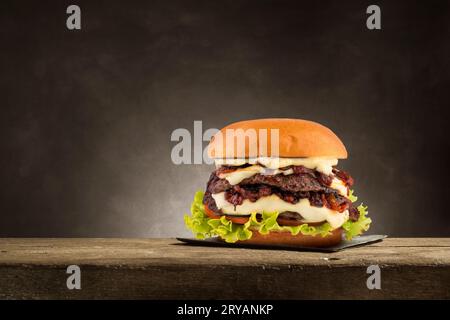 Classic hamburger with grilled meat on wooden table. Stock Photo