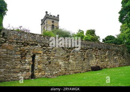 Ruins of Medieval arched cloisters at historic Culross Abbey in Culross, Fife, Scotland. The intact church tower is visible beyond the stone wall. Stock Photo