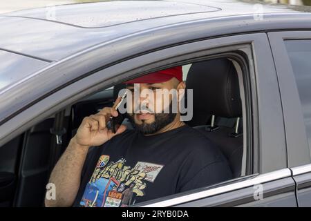 man with a beard talking on the phone in the car Stock Photo