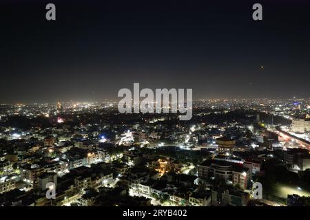 aerial drone tripod shot showing cityscape of jaipur delhi with fireworks, rockets, pyrotechnics and sky lanterns at night in celebration of makar Stock Photo