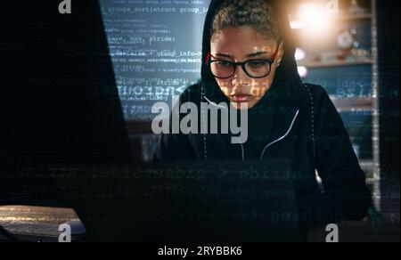 Hacker, woman in dark room with laptop and code, data analysis and IT, phishing and cyber crime with database. Cybersecurity, programming and criminal Stock Photo