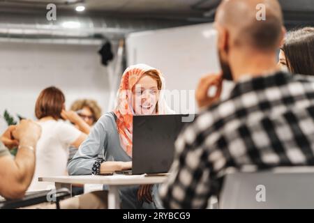 Group of diverse people smiling, communicating and working on a project in groups Stock Photo
