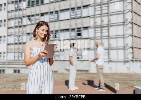 A diverse group of professionals collaborating on a construction project in the urban city. They discuss blueprints and analyze statistics to ensure s Stock Photo