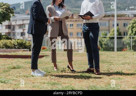 Cropped shot of stylish business people holding and discussing paperwork outdoors Stock Photo