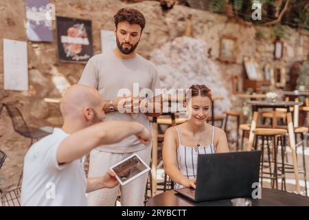 A group of professionals discussing business strategies and analyzing data in a cafe bar. Stock Photo