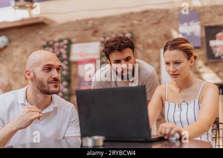 A diverse group of professionals collaborate in a cafe, analyzing data, discussing strategies for online retail, and working on new projects. Stock Photo