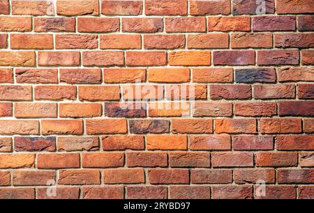 Brick tile wall abstract background. Exterior view of a house made of blocks lined with cement. Exterior wall made of decorative brickwork. Stock Photo