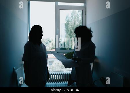 Professionals in a healthcare group communicate, collaborate, and discuss patients results in a modern clinic. They work together to provide successfu Stock Photo