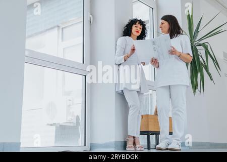 In a healthcare clinic, doctors collaborate on patient results. They discuss and plan therapy, demonstrating successful teamwork. Stock Photo