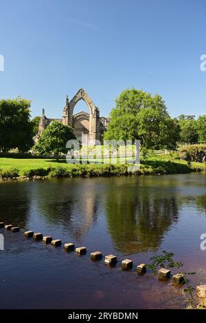 Stepping stones across the river Wharfe beside the ruins of Bolton Abbey, North Yorkshire. Stock Photo