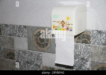 A tissue holder holds white tissue paper on the wall. Stock Photo