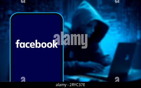 A conceptual close-up of a smartphone screen displaying the Facebook logo alongside scrolling lines of green computer code. This editorial image illus Stock Photo