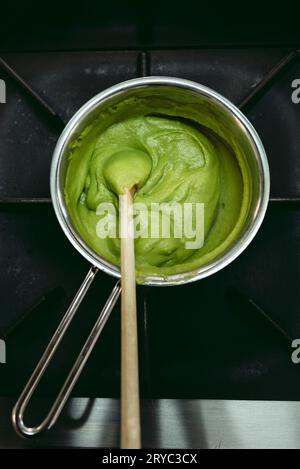 Frozen spinach in the pot - prepared to cook. Green balls of frozen spinach - cuisine concept. Stock Photo