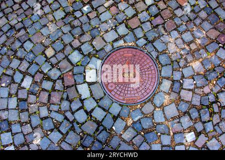 Manhole cover of the gas pipeline system. A massive metal hatch for access to city communications in the pavement. Stock Photo