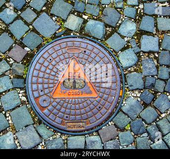 Manhole cover of the gas pipeline system. A massive metal hatch for access to city communications in the pavement. Stock Photo