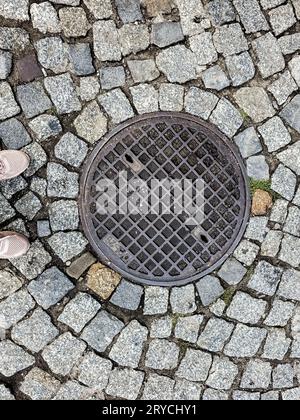 Manhole cover of the gas pipeline system. A massive metal hatch for access to city communications in the pavement. Stock Photo