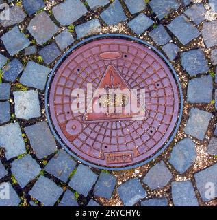 Manhole cover of the gas pipeline system. A massive metal hatch for access to city communications in the pavement. Stock Photo