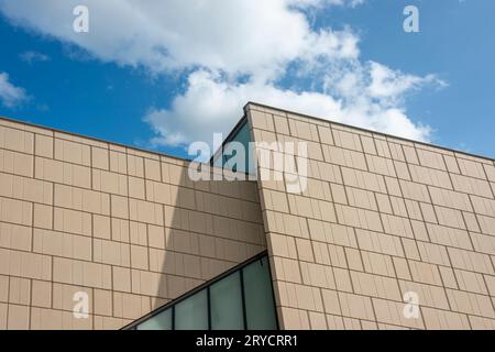Low angle view of a modern architectural building against a blue sky Stock Photo